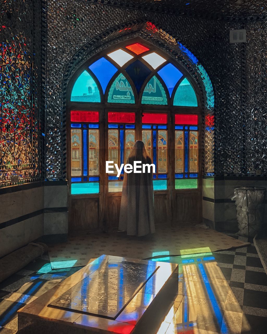 REAR VIEW OF WOMAN WALKING BY WINDOW IN TEMPLE