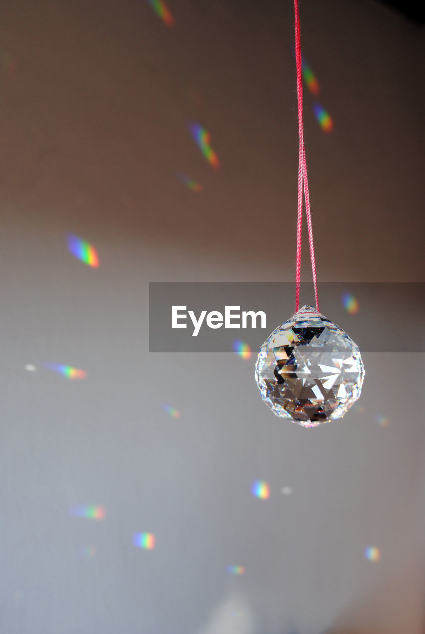 Close-up of crystal ball hanging against wall