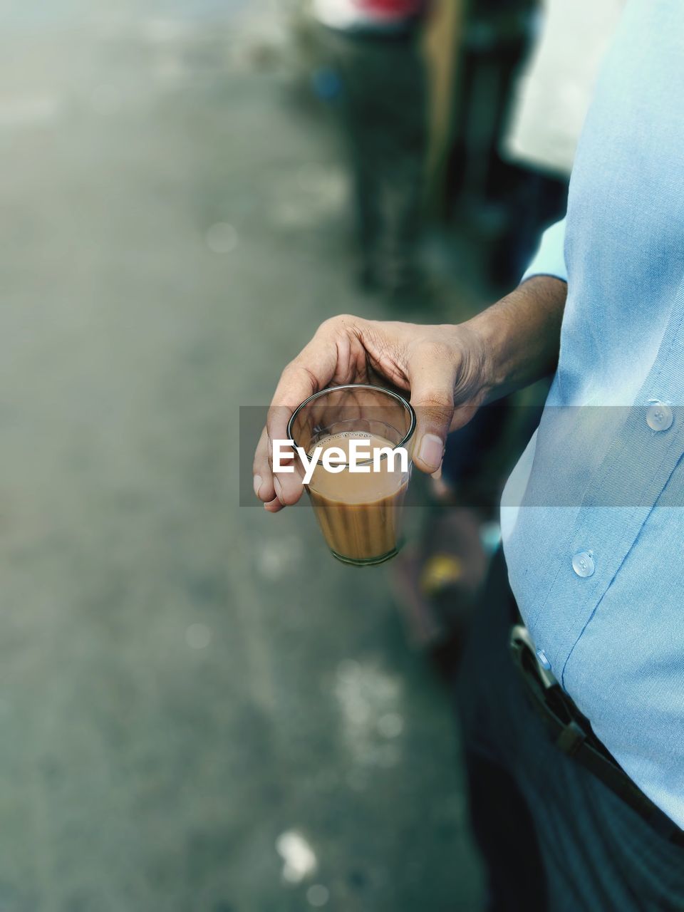 Midsection of man having tea outdoors