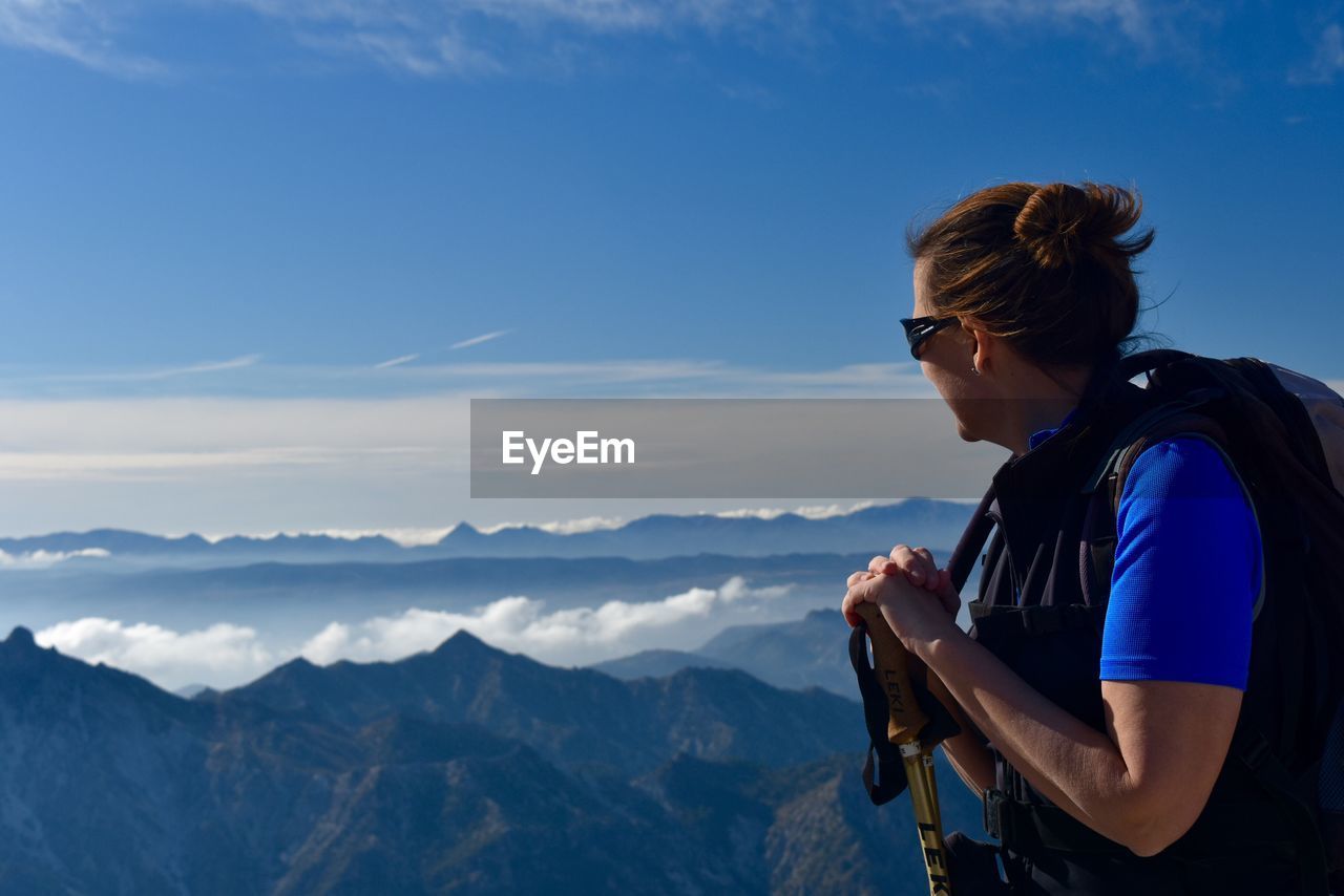 Hiker with hiking pole looking at mountains