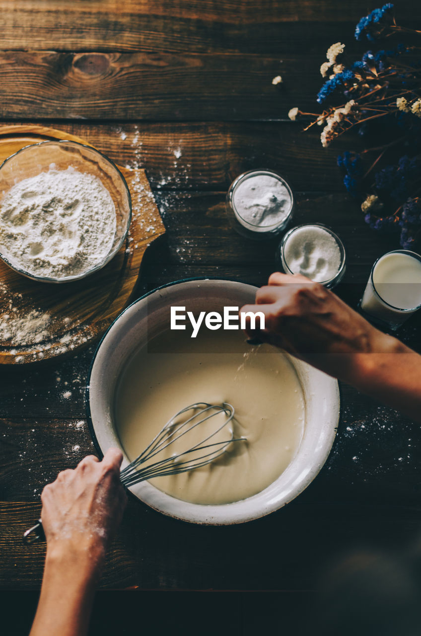 HIGH ANGLE VIEW OF WOMAN PREPARING FOOD IN KITCHEN