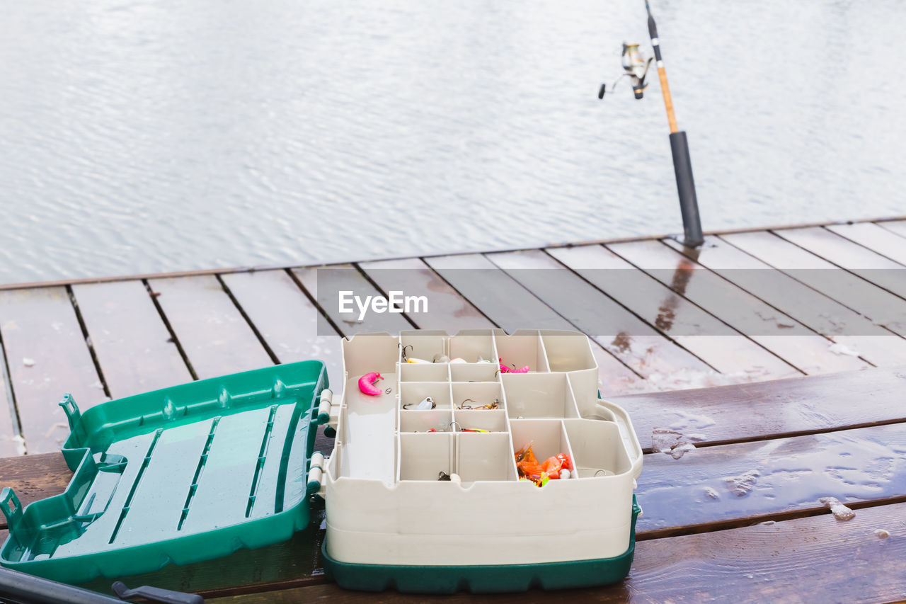 HIGH ANGLE VIEW OF TOY FLOATING ON TABLE BY SEA