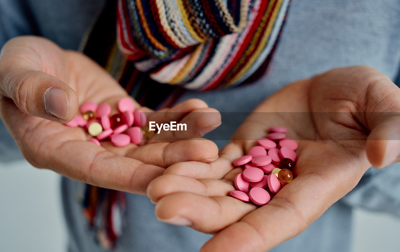 Midsection of man showing pills