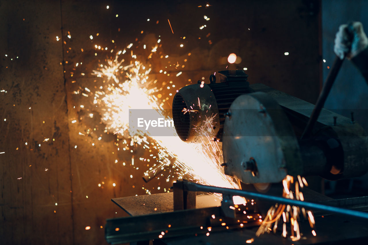 low angle view of man welding metal at night