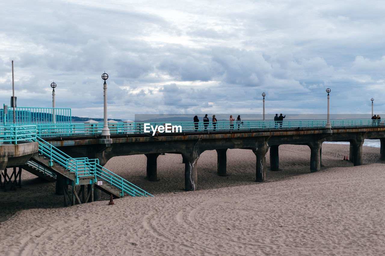 PEOPLE AT BRIDGE AGAINST SKY