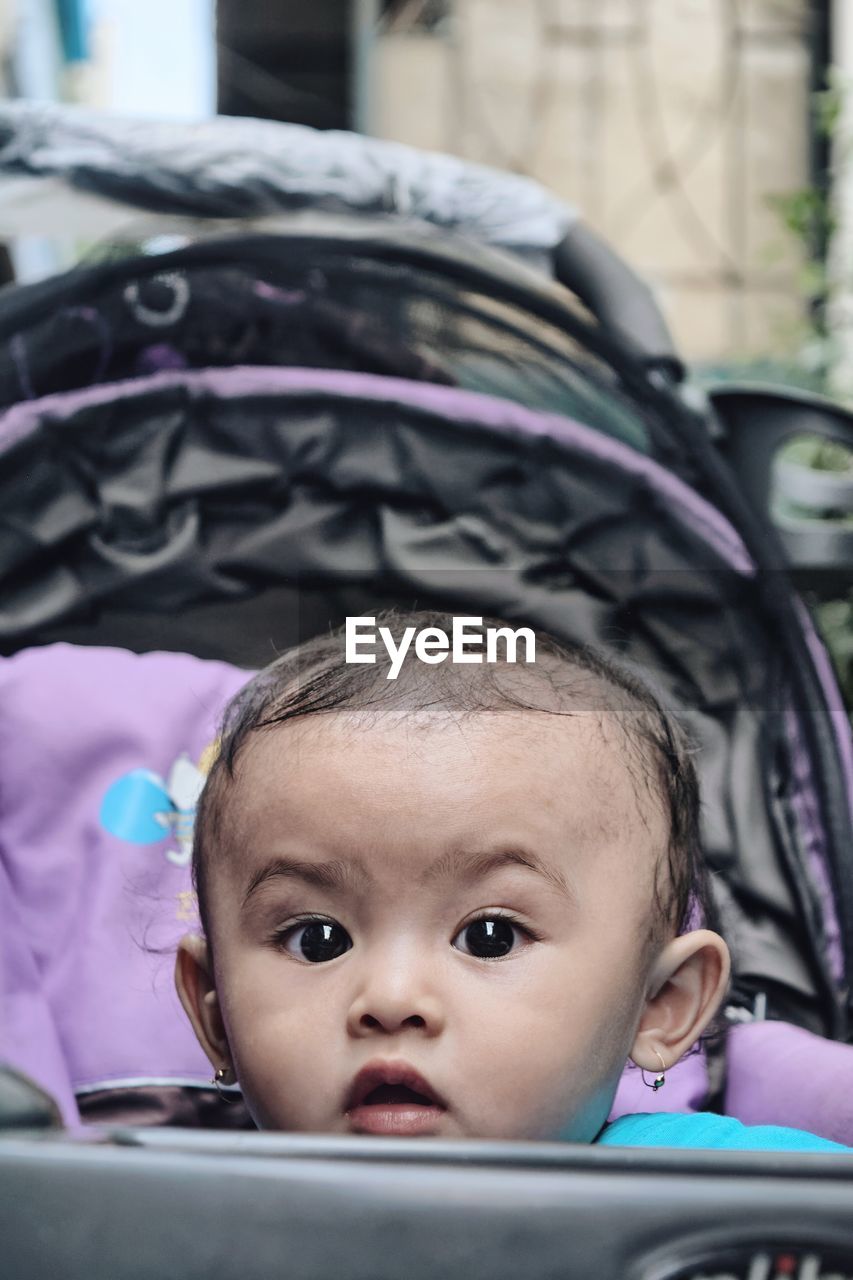 Portrait of cute baby girl in carriage