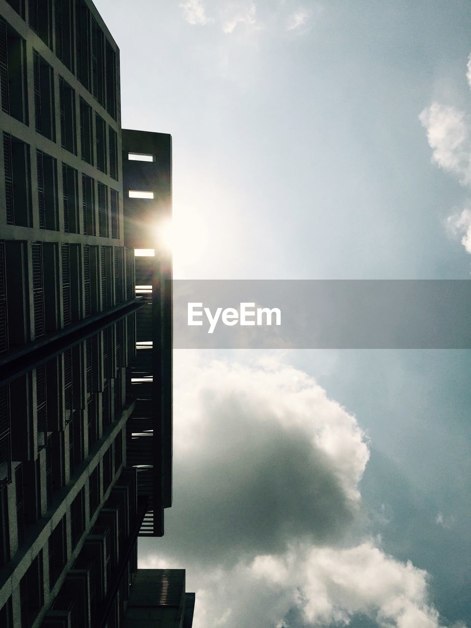 LOW ANGLE VIEW OF BUILDINGS AGAINST CLOUDY SKY