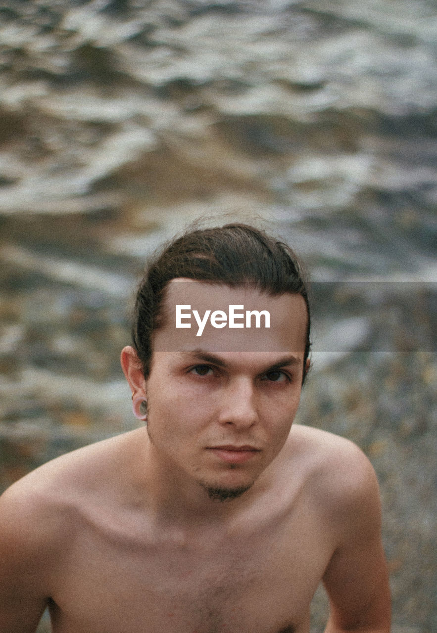 Close-up portrait of shirtless young man