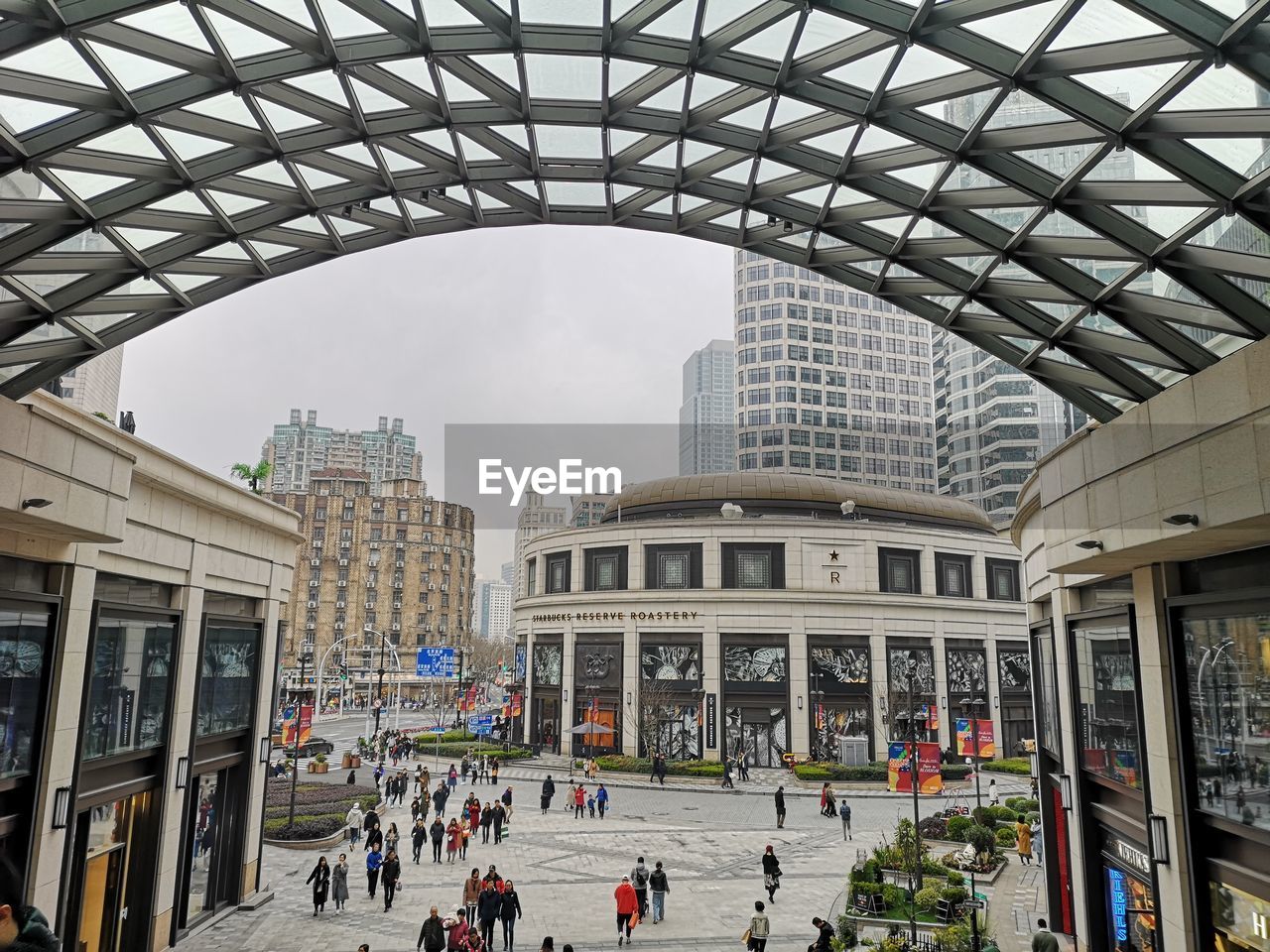 PEOPLE IN MODERN BUILDING AGAINST SKY