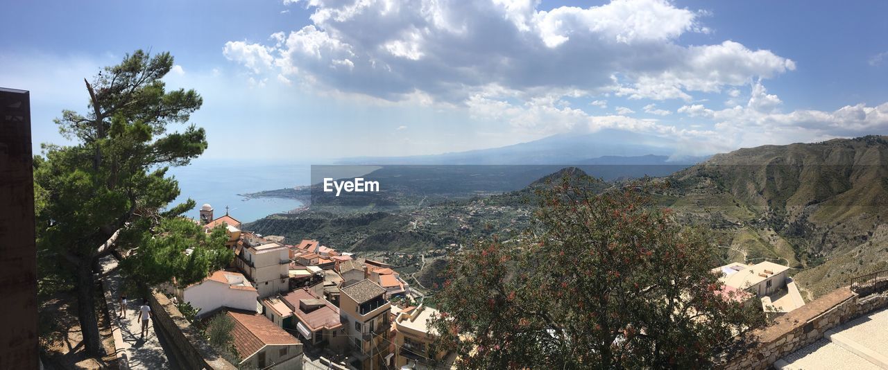 HIGH ANGLE VIEW OF TOWNSCAPE BY MOUNTAIN AGAINST SKY