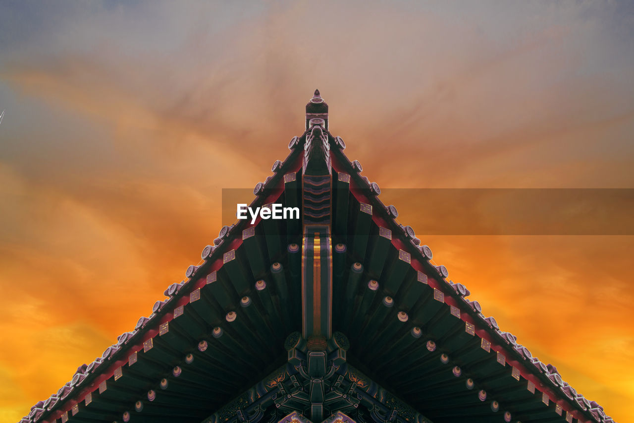 High section of temple roof against clouds