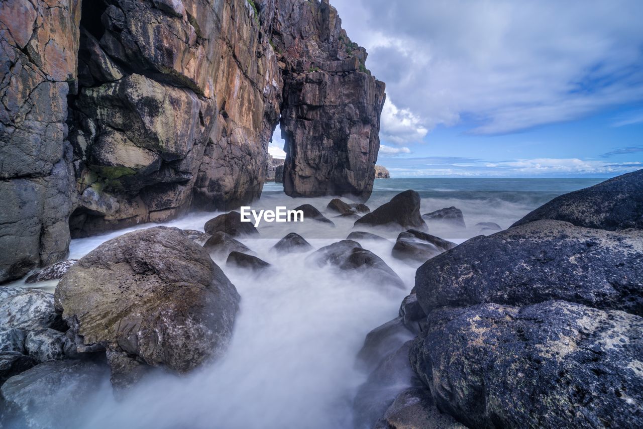 Scenic view of rocks in sea against sky