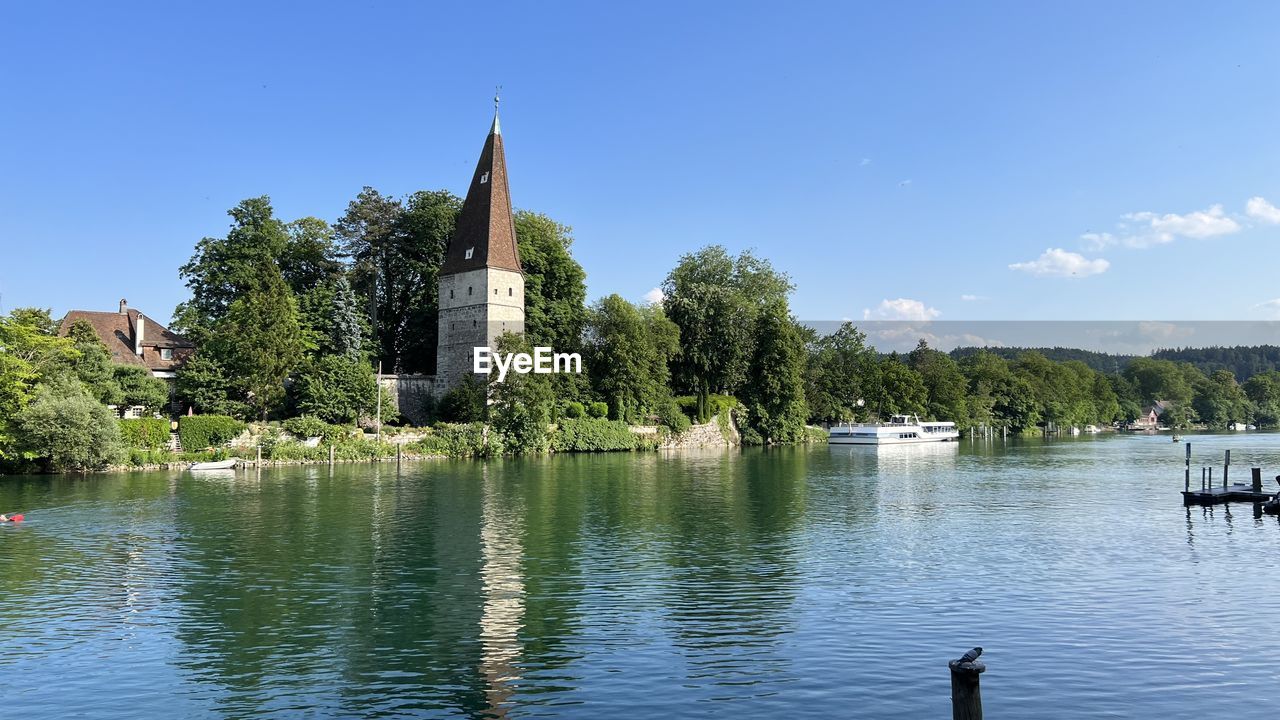 water, reflection, sky, architecture, tree, built structure, nature, lake, building exterior, plant, building, travel destinations, blue, religion, place of worship, no people, travel, beauty in nature, day, reservoir, tower, tranquility, outdoors, clear sky, scenics - nature, landscape, belief, body of water, tourism, sunny, city, summer, spirituality, history, environment, cloud, nautical vessel, tranquil scene, the past