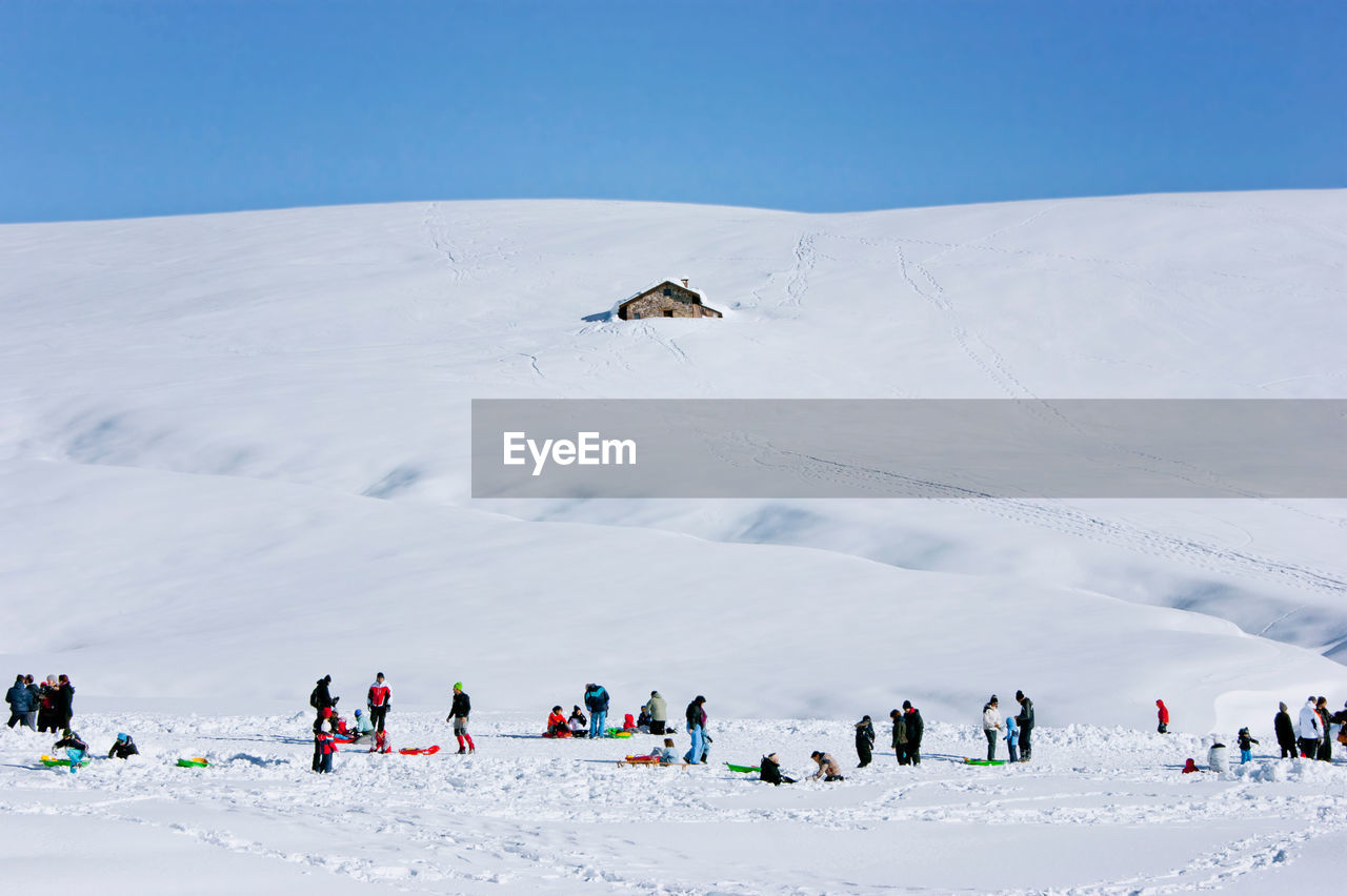 Group of people skiing on snowcapped mountain