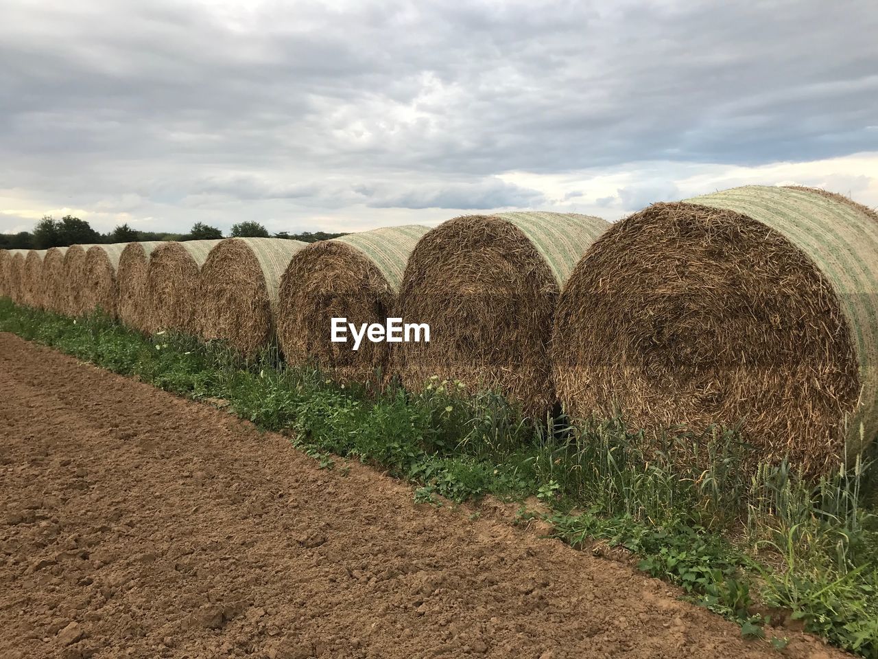 Hay bales on field against sky