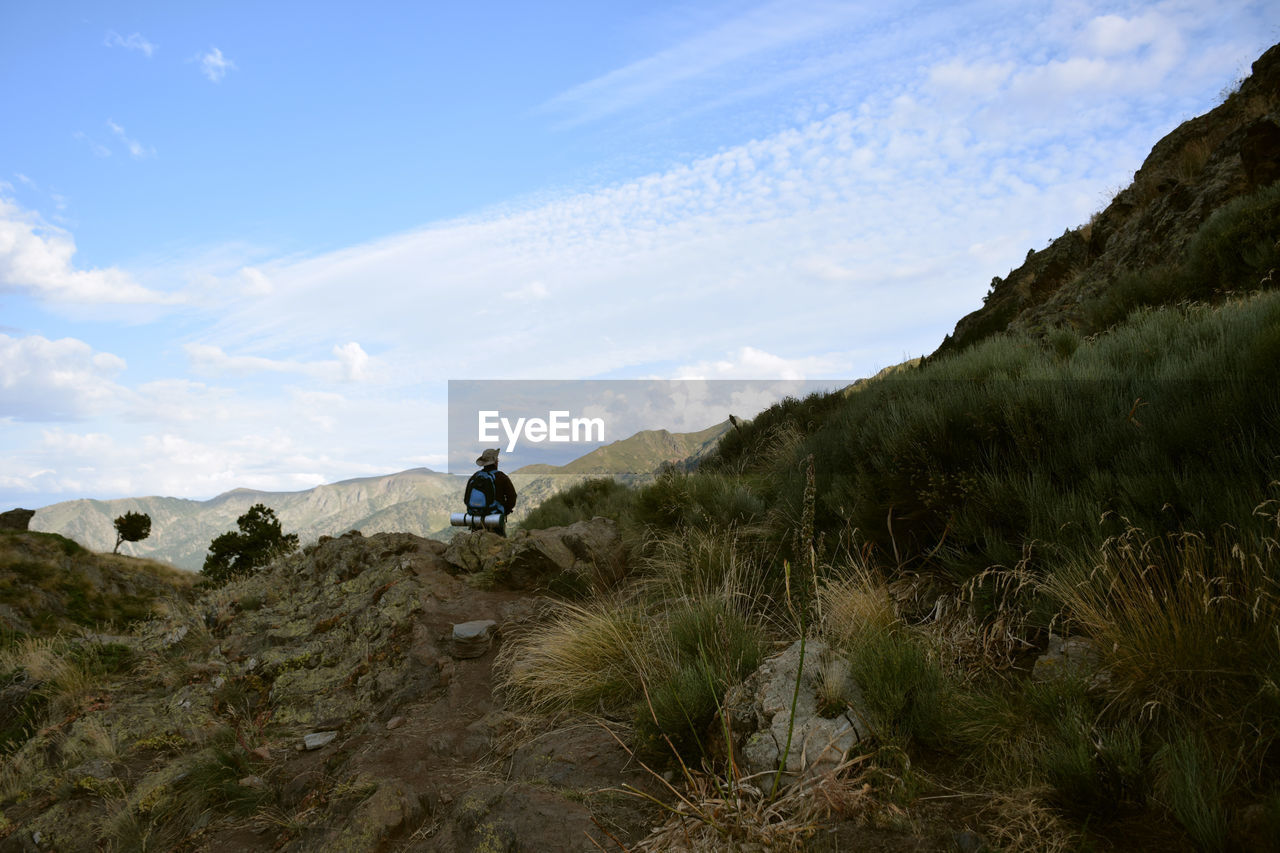 Rear view of man on mountain against sky