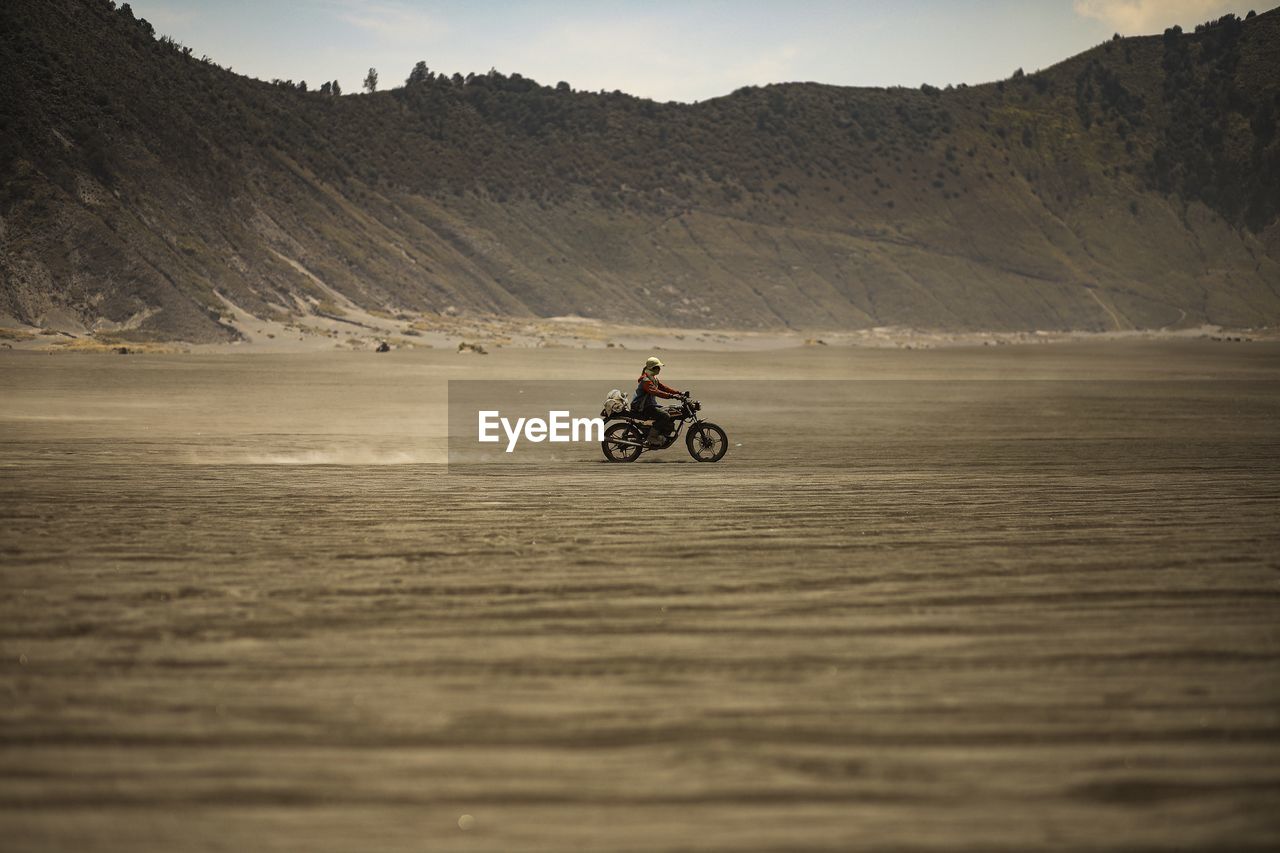 MAN RIDING MOTORCYCLE ON MOUNTAIN