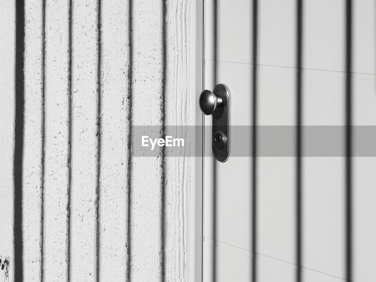 security, protection, metal, door, entrance, no people, close-up, lock, closed, day, pattern, white, full frame, architecture, interior design, knob, door handle, built structure, wall - building feature, line, iron, wood, wall, hanging, doorknob, outdoors, backgrounds, security system