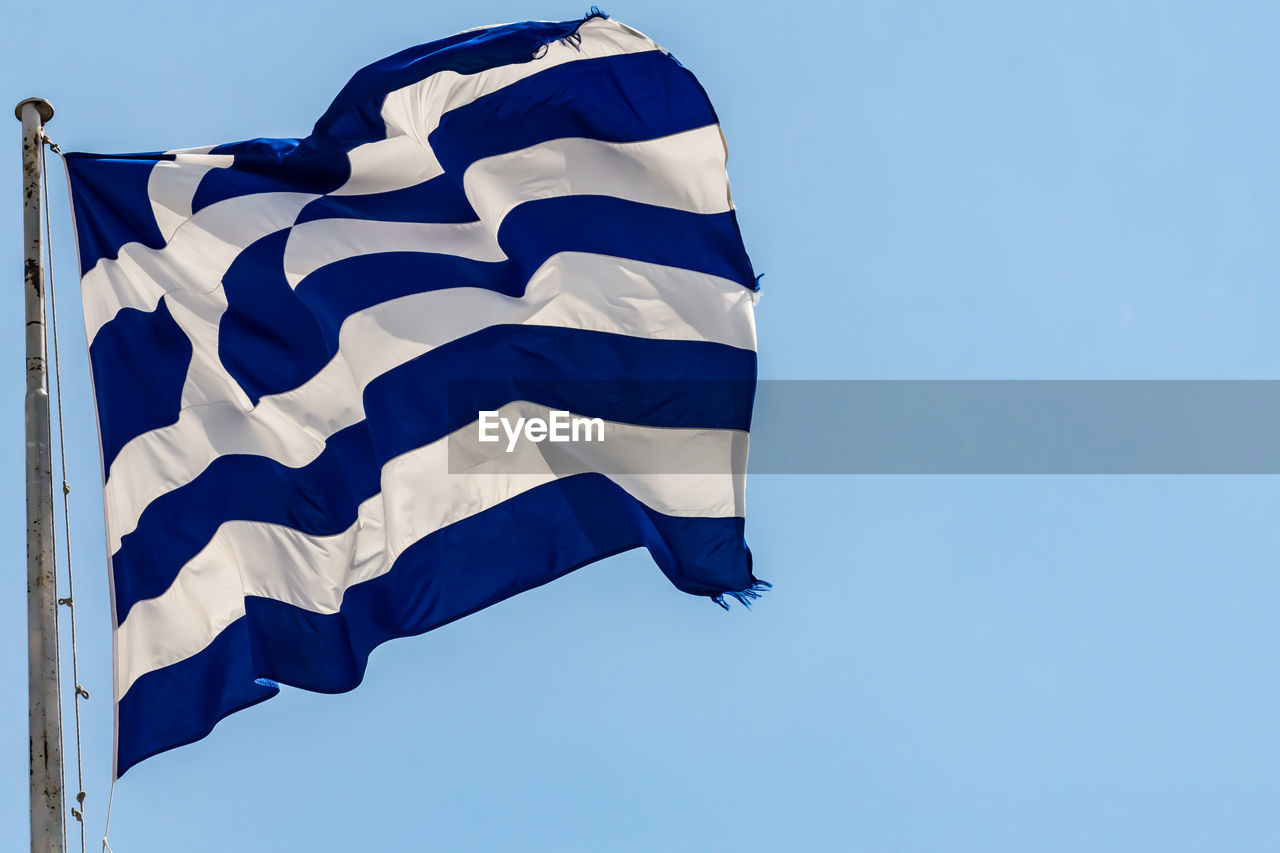 Greek national flag waving on blue sky background. hellenic republic, gr 