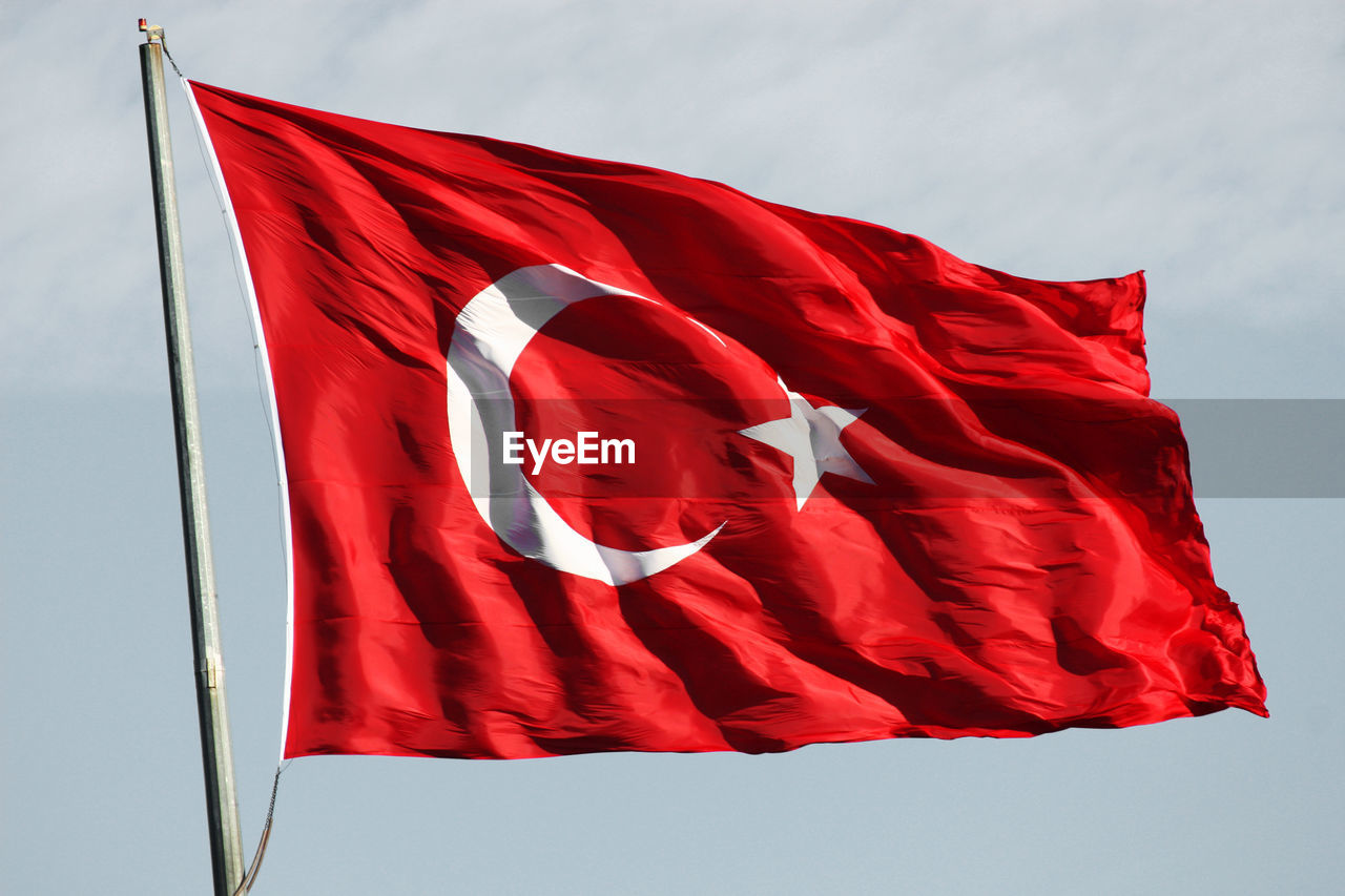 LOW ANGLE VIEW OF FLAG ON RED UMBRELLA