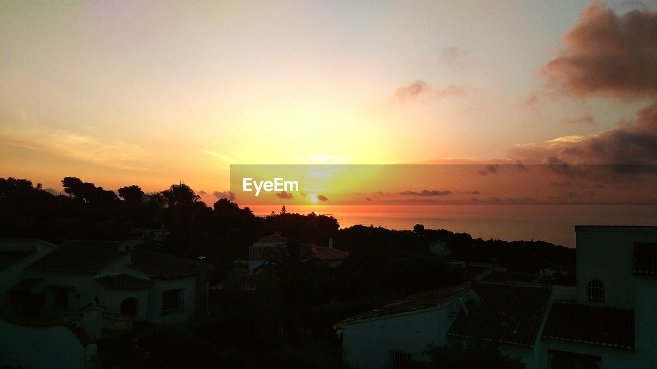 HIGH ANGLE VIEW OF CITYSCAPE AT SUNSET