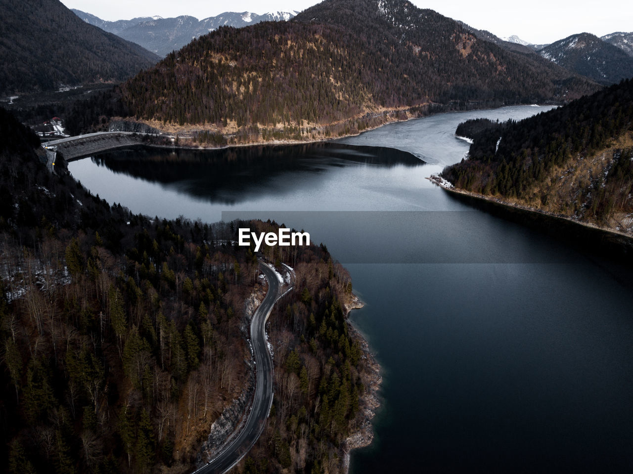 Aerial view of river amidst mountains against sky