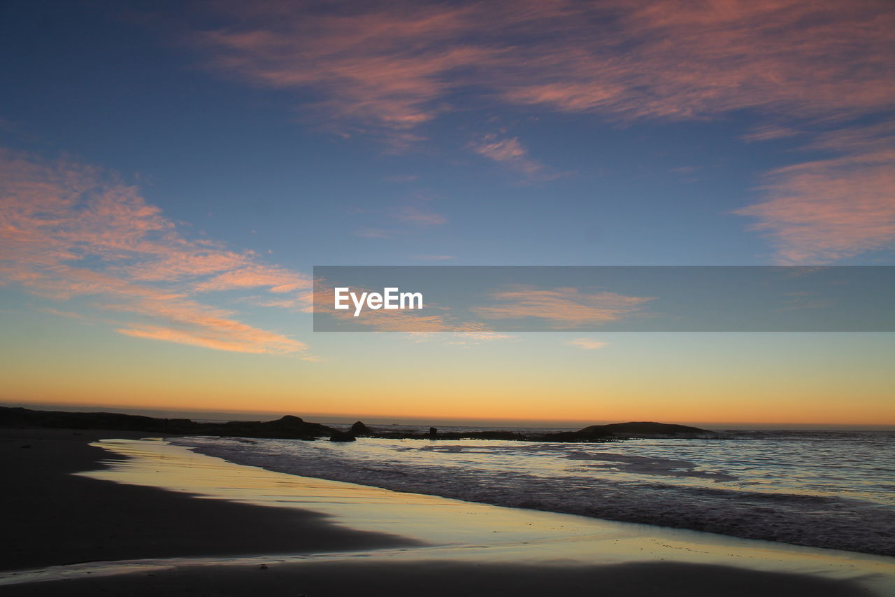 Scenic view of beach against sky during sunset