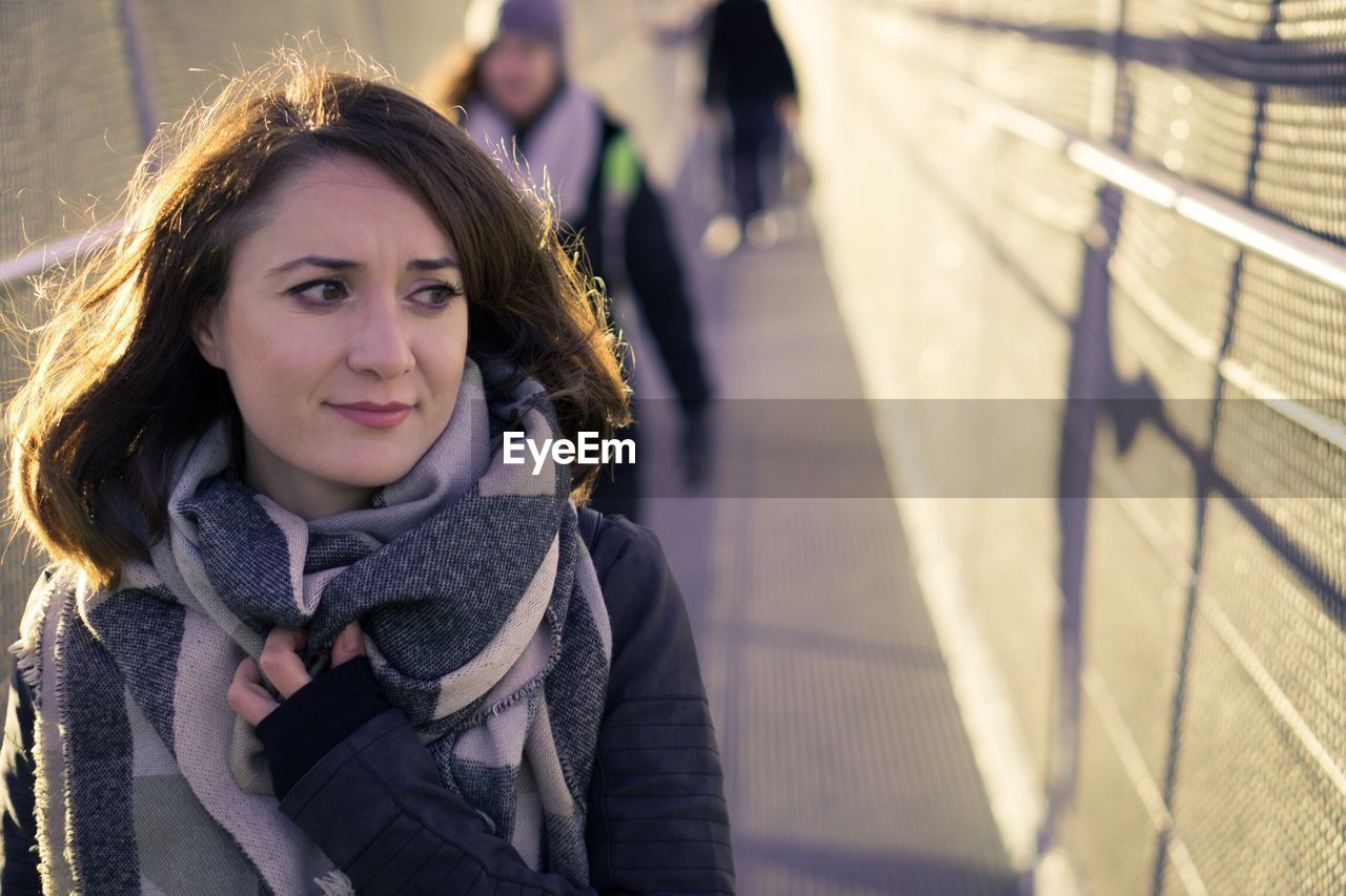 Young woman wearing scarf on footbridge