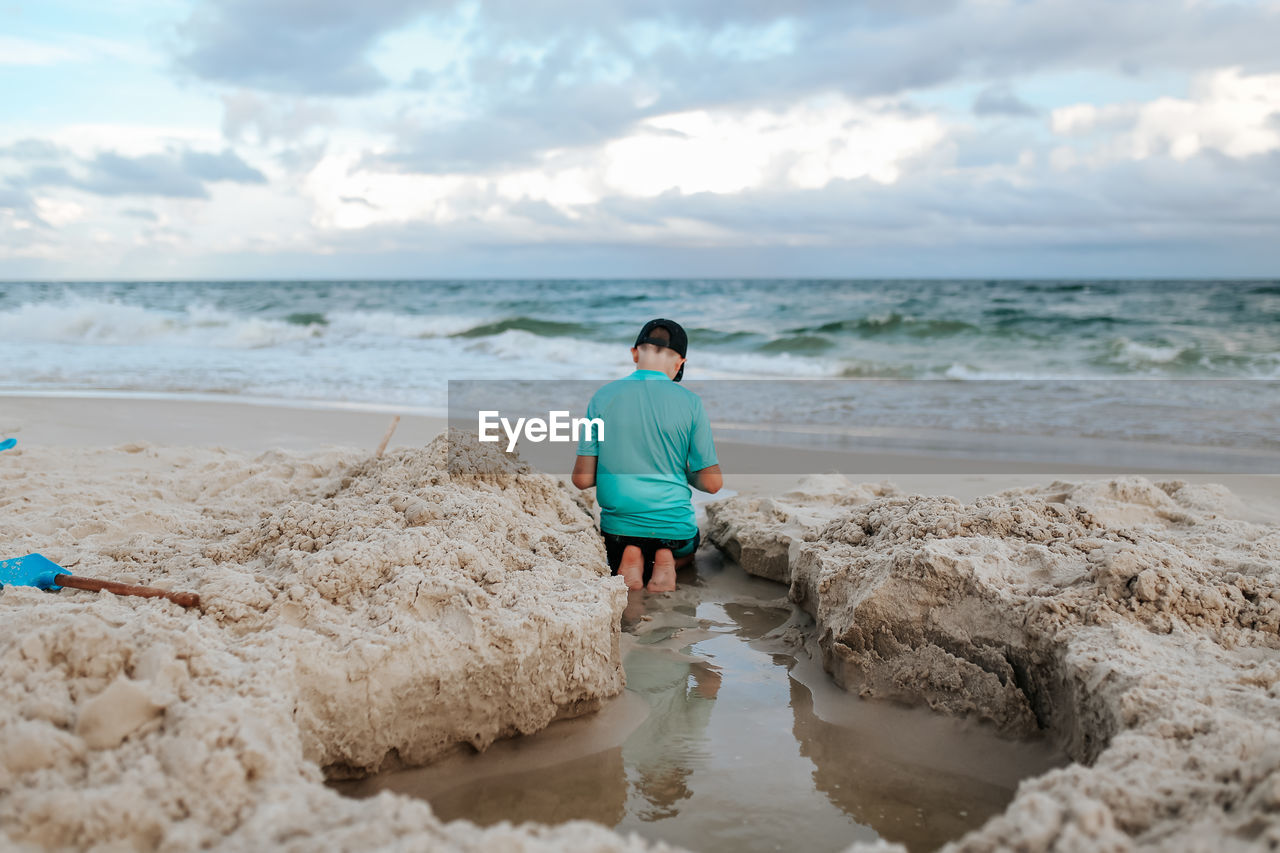 REAR VIEW OF WOMAN ON BEACH