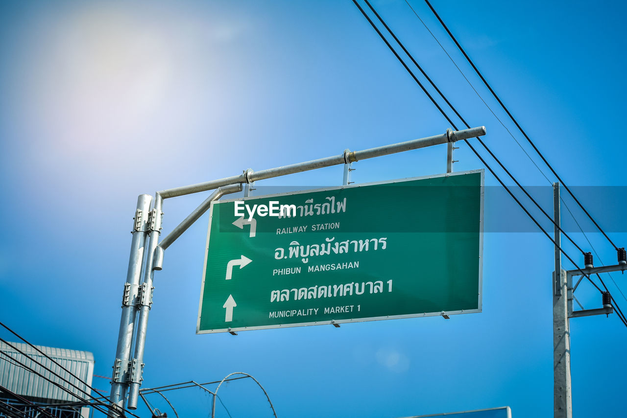 Low angle view of road signs against blue sky