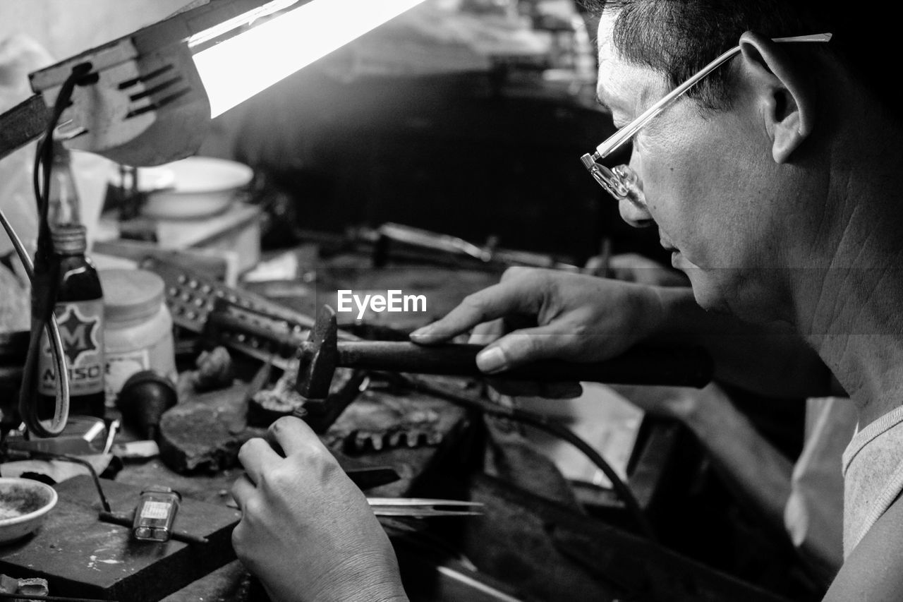 Mid adult man using hammer in workshop