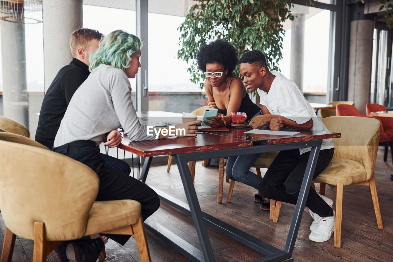 Group of multi ethnic people with alternative girl with green hair is working together