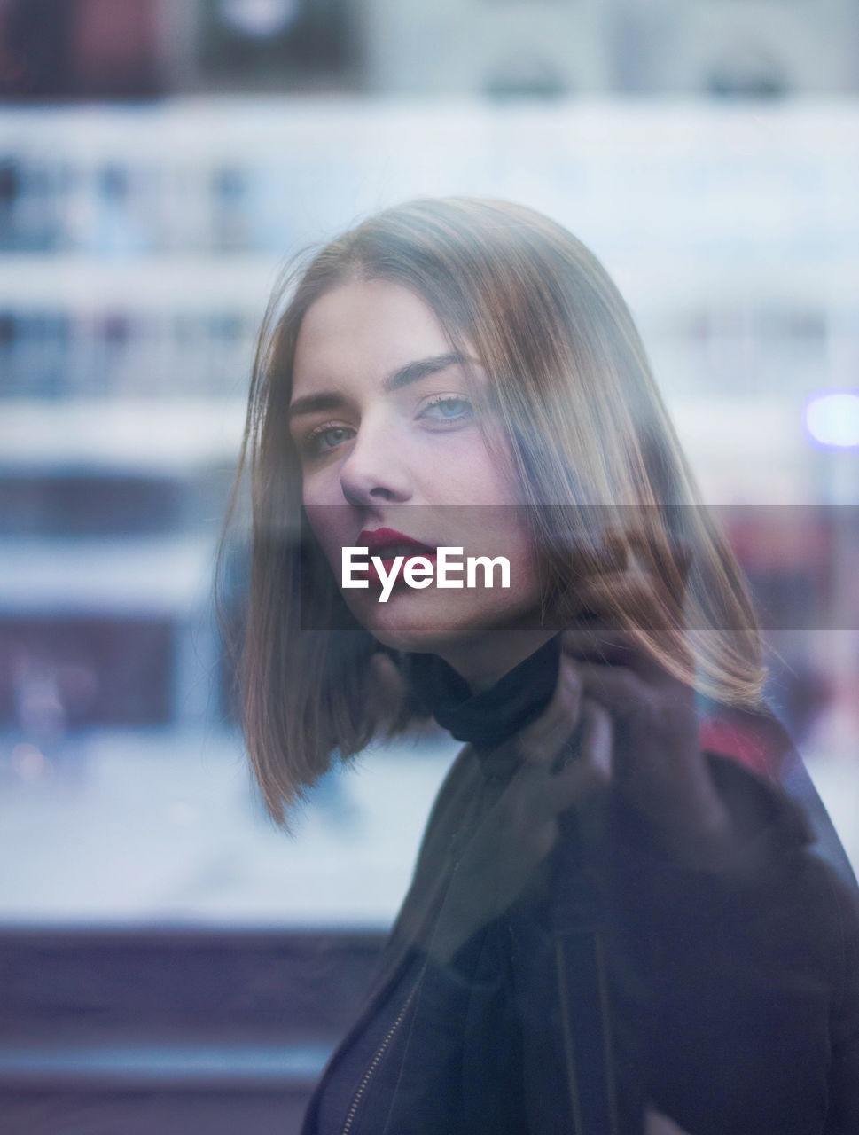 Close-up portrait of young beautiful woman in city