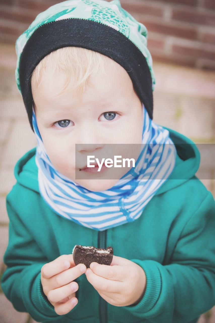 Close-up portrait of boy holding cookie
