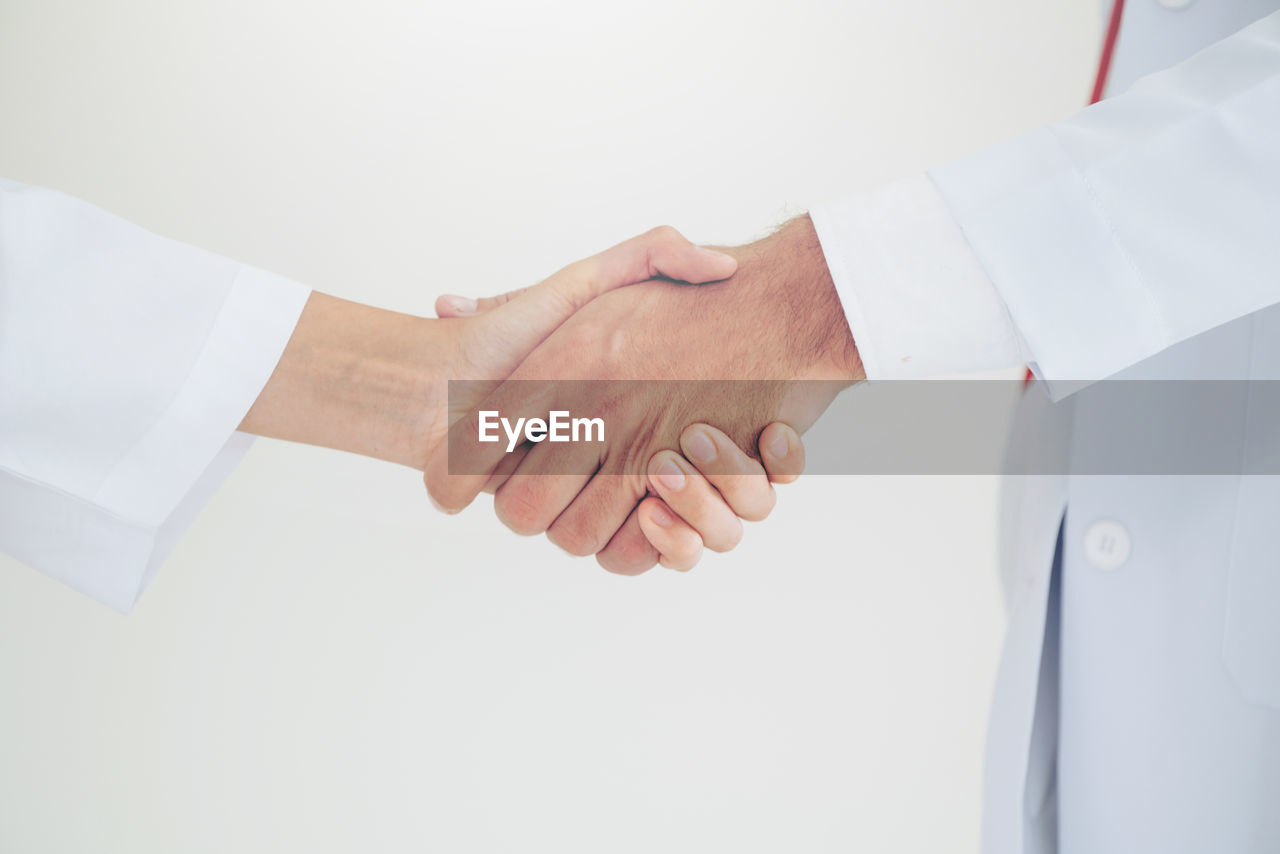 Midsection of doctors shaking hands