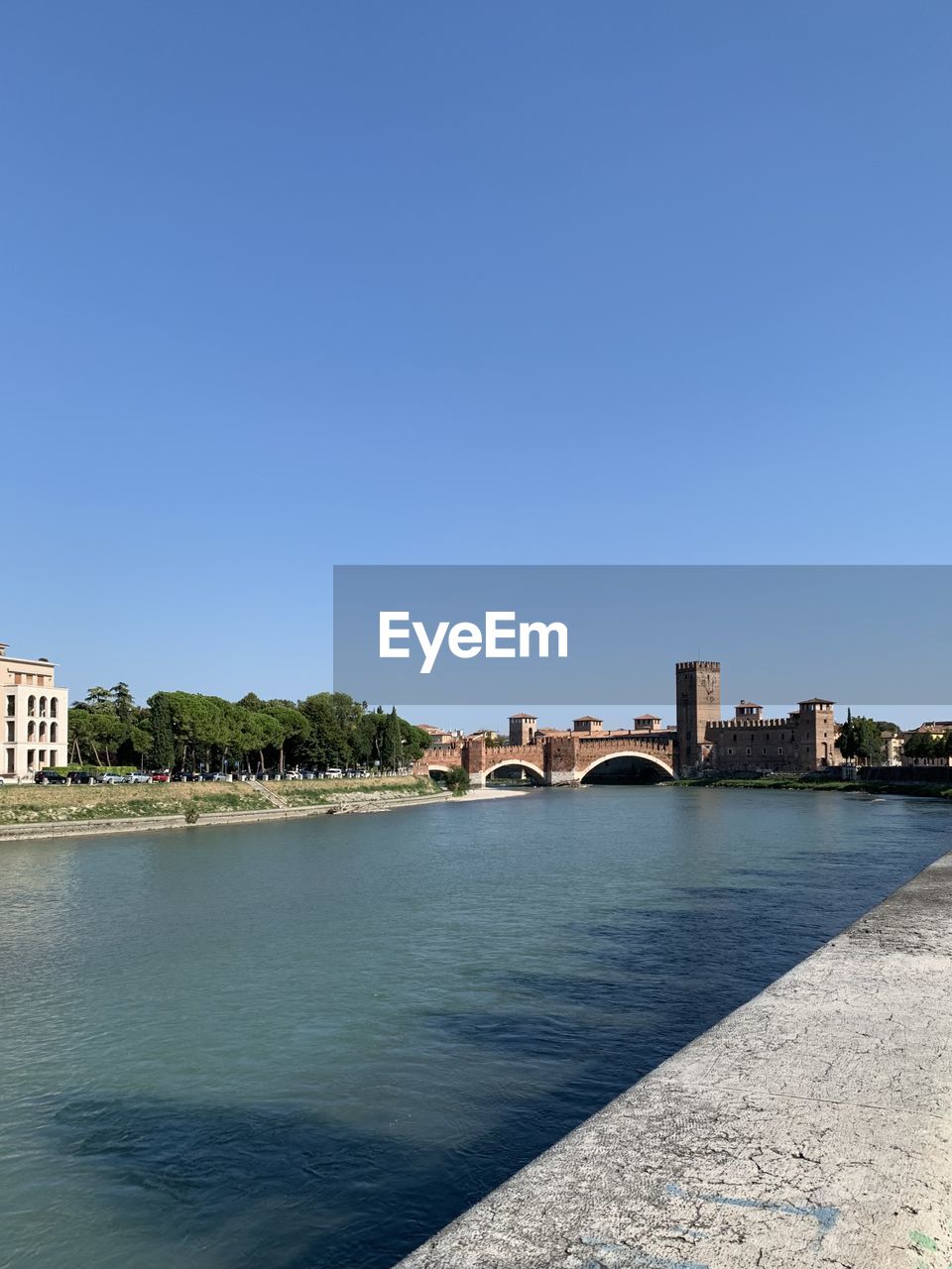 Arch bridge over river against buildings