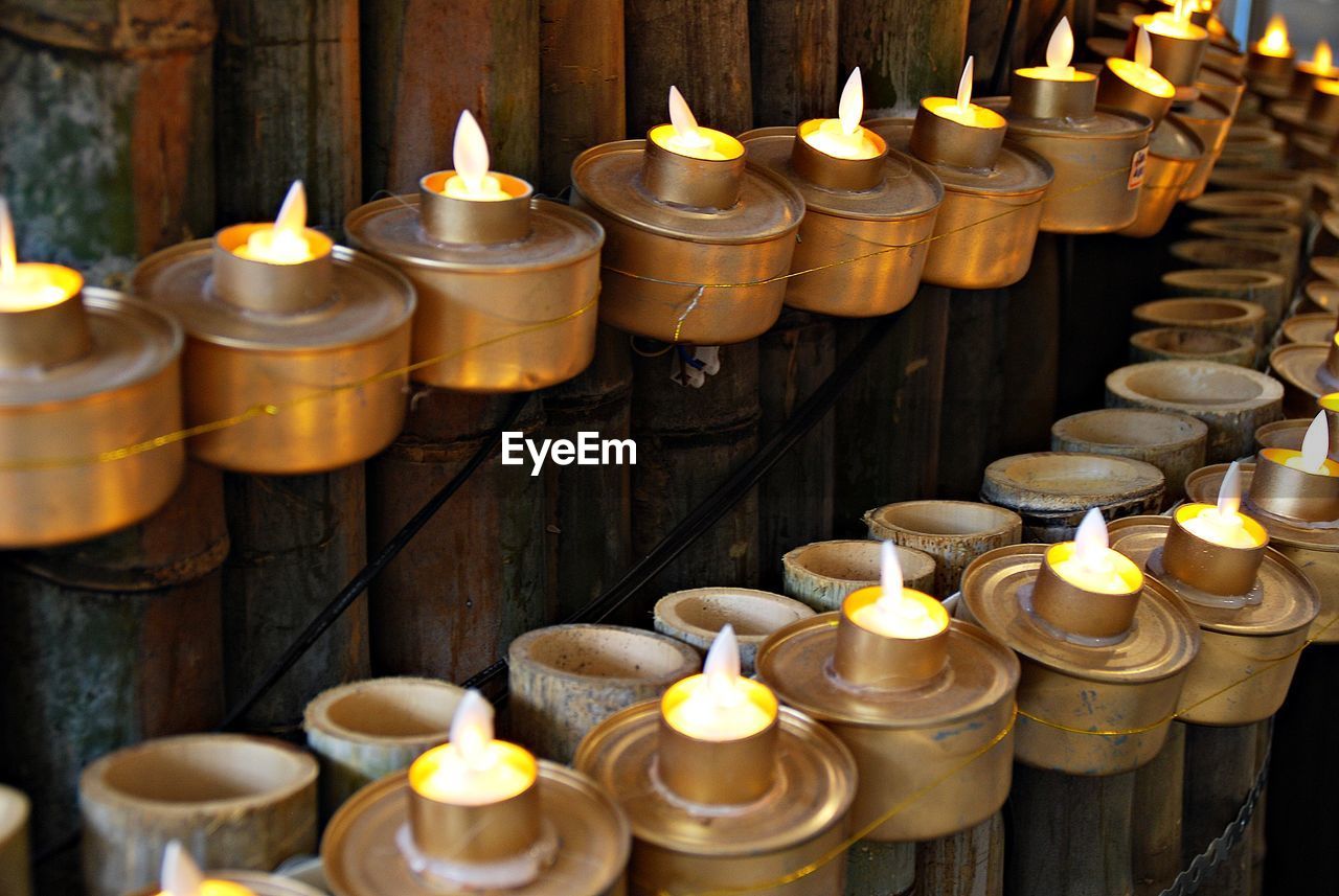 Lit oil lamps mounted on bamboo fence