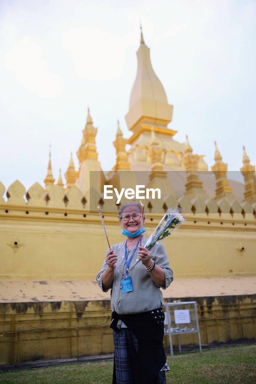 Grandma happy and smiling at that luang stupa