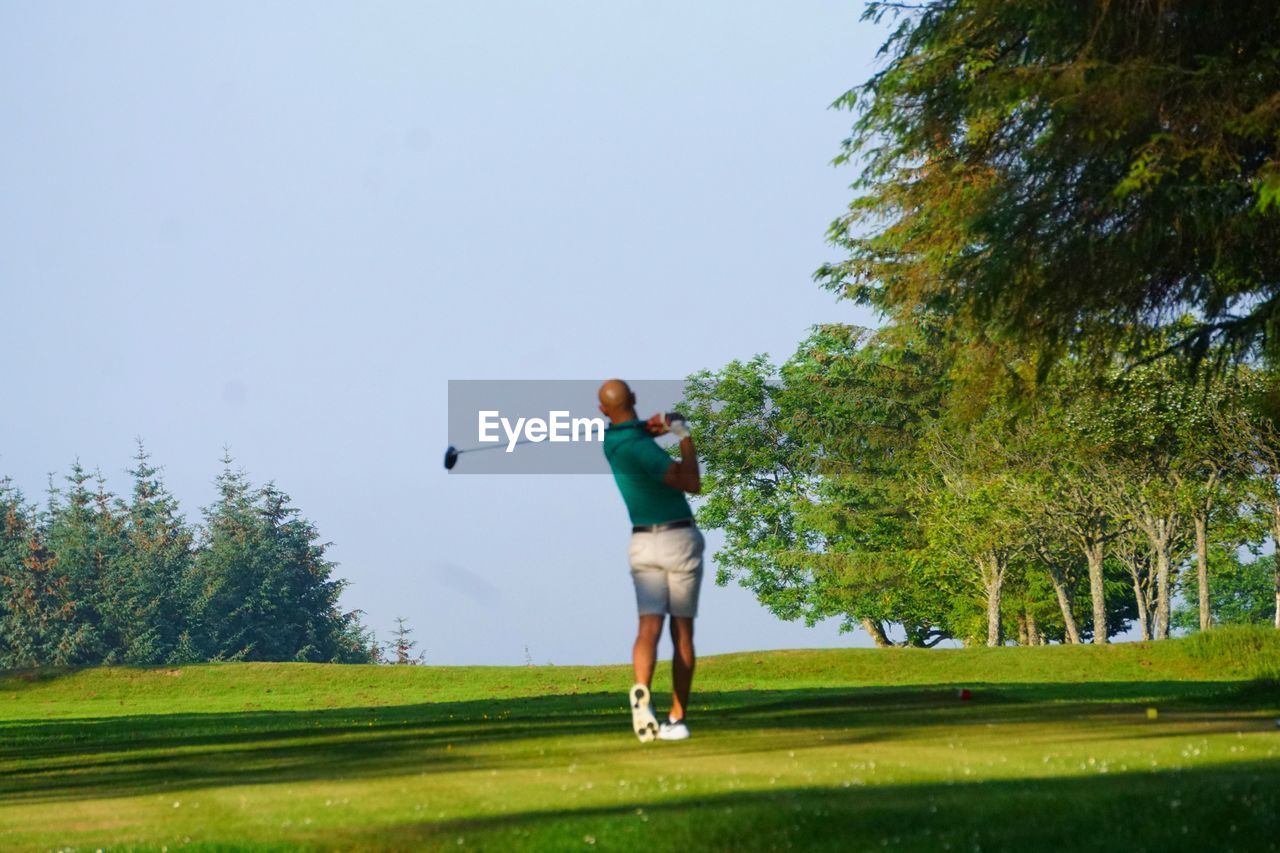 Full length of man on golf course against sky