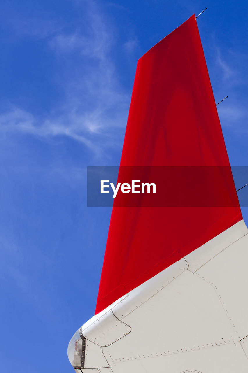 Airliner wing tip against a deep blue sky