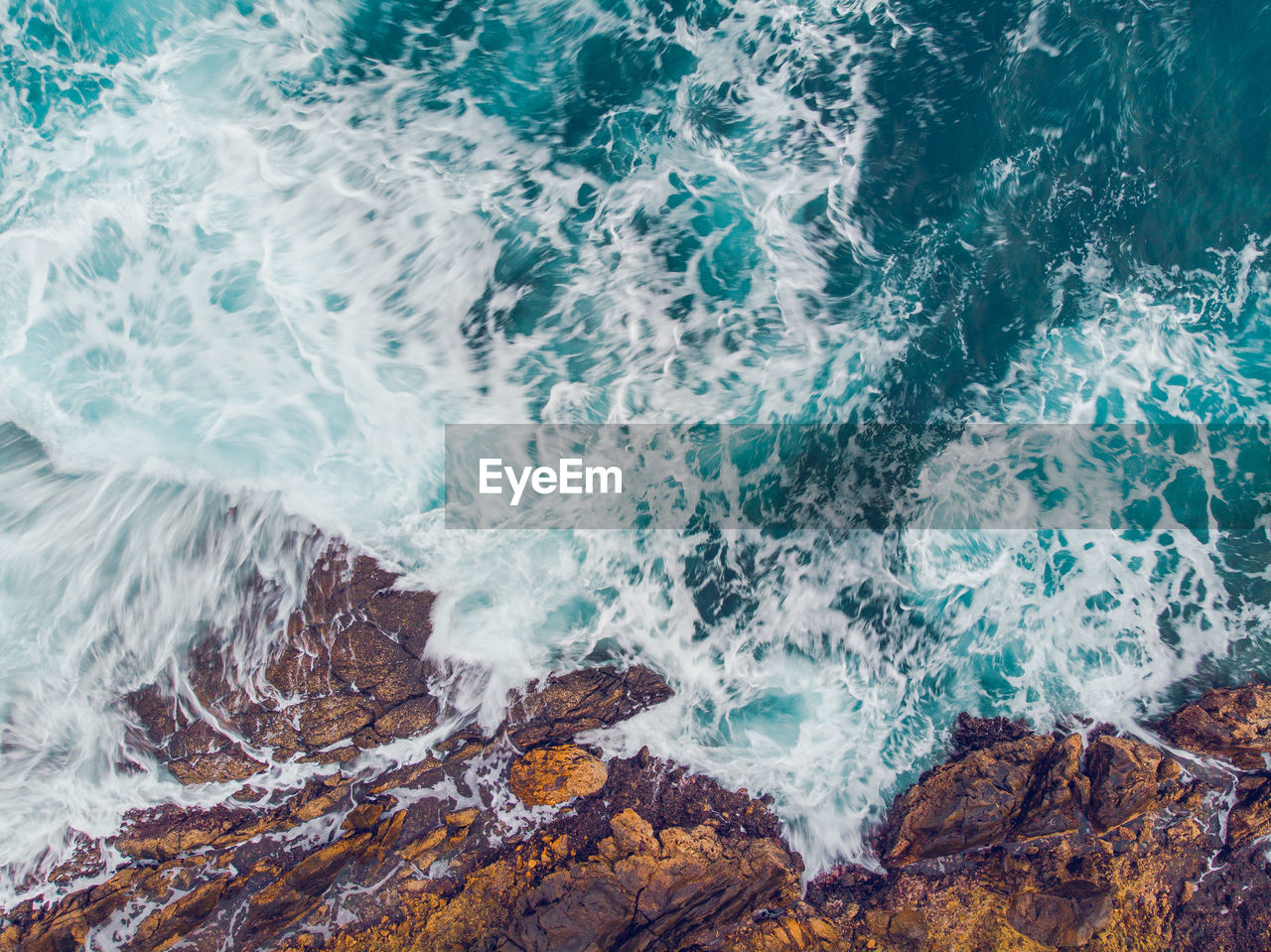 Full frame shot of waves breaking on rocks