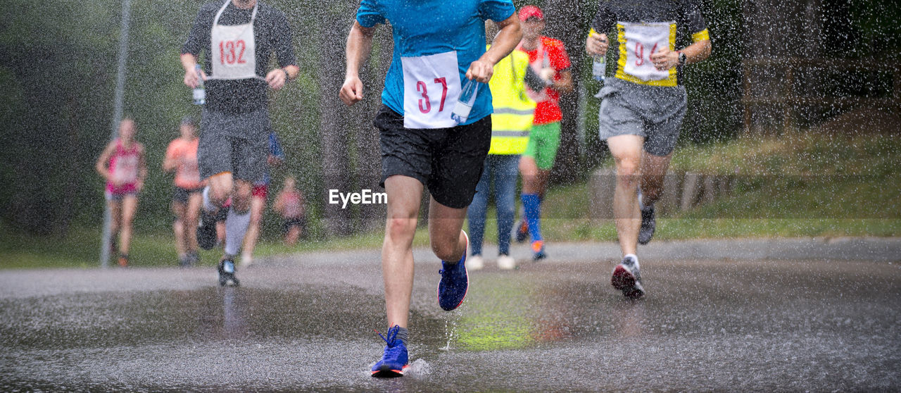 People running on wet street during rainy season