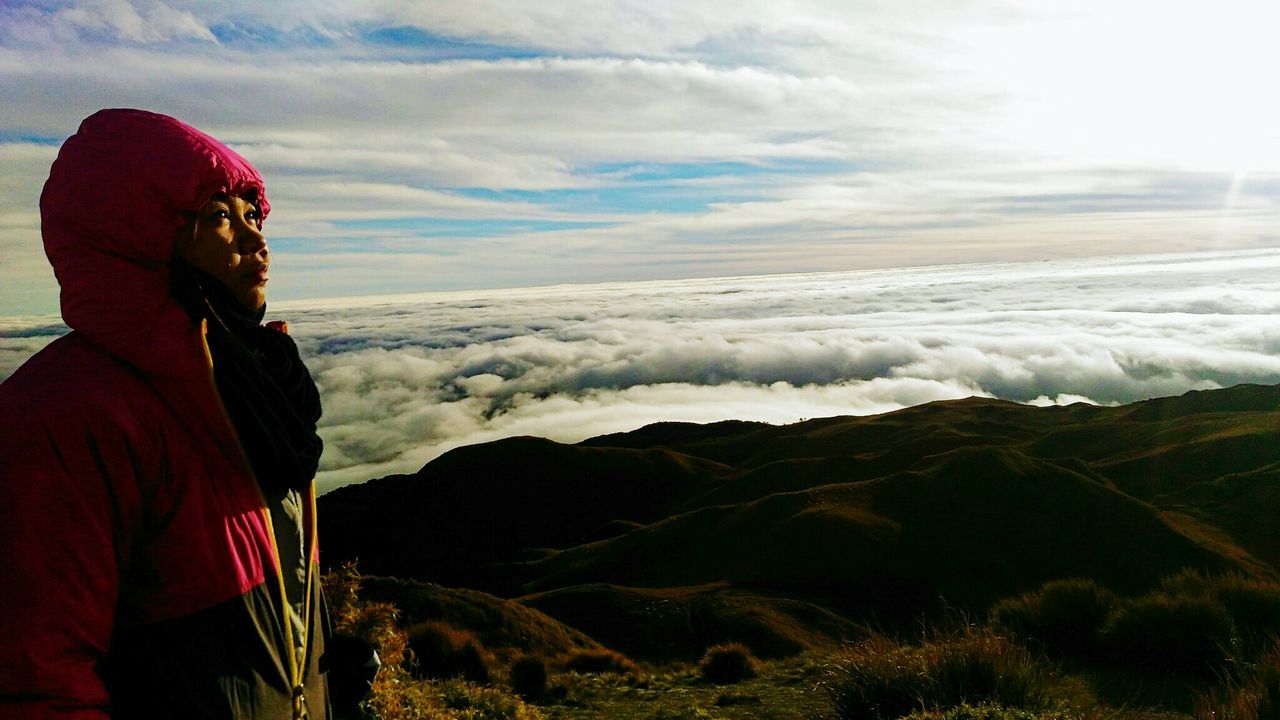 Woman standing on mount pulag against cloudy sky