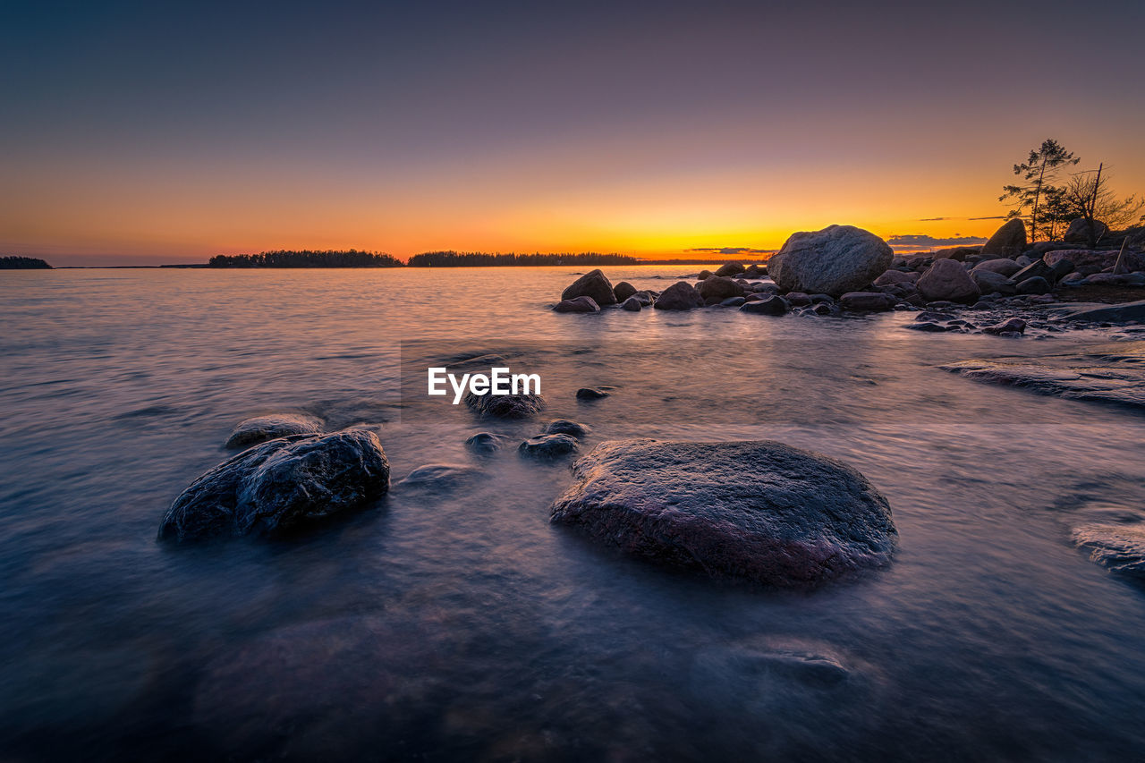 Rocks in lake at sunset