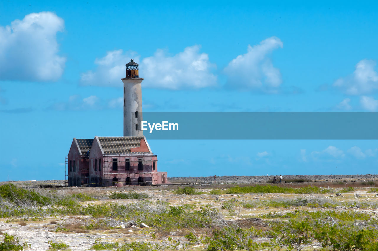 lighthouse by sea against sky