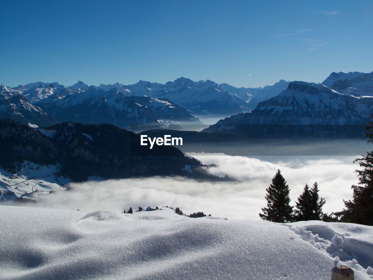 Scenic view of snowcapped mountains against blue sky