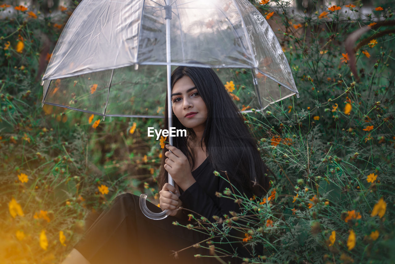 PORTRAIT OF A BEAUTIFUL YOUNG WOMAN WITH UMBRELLA