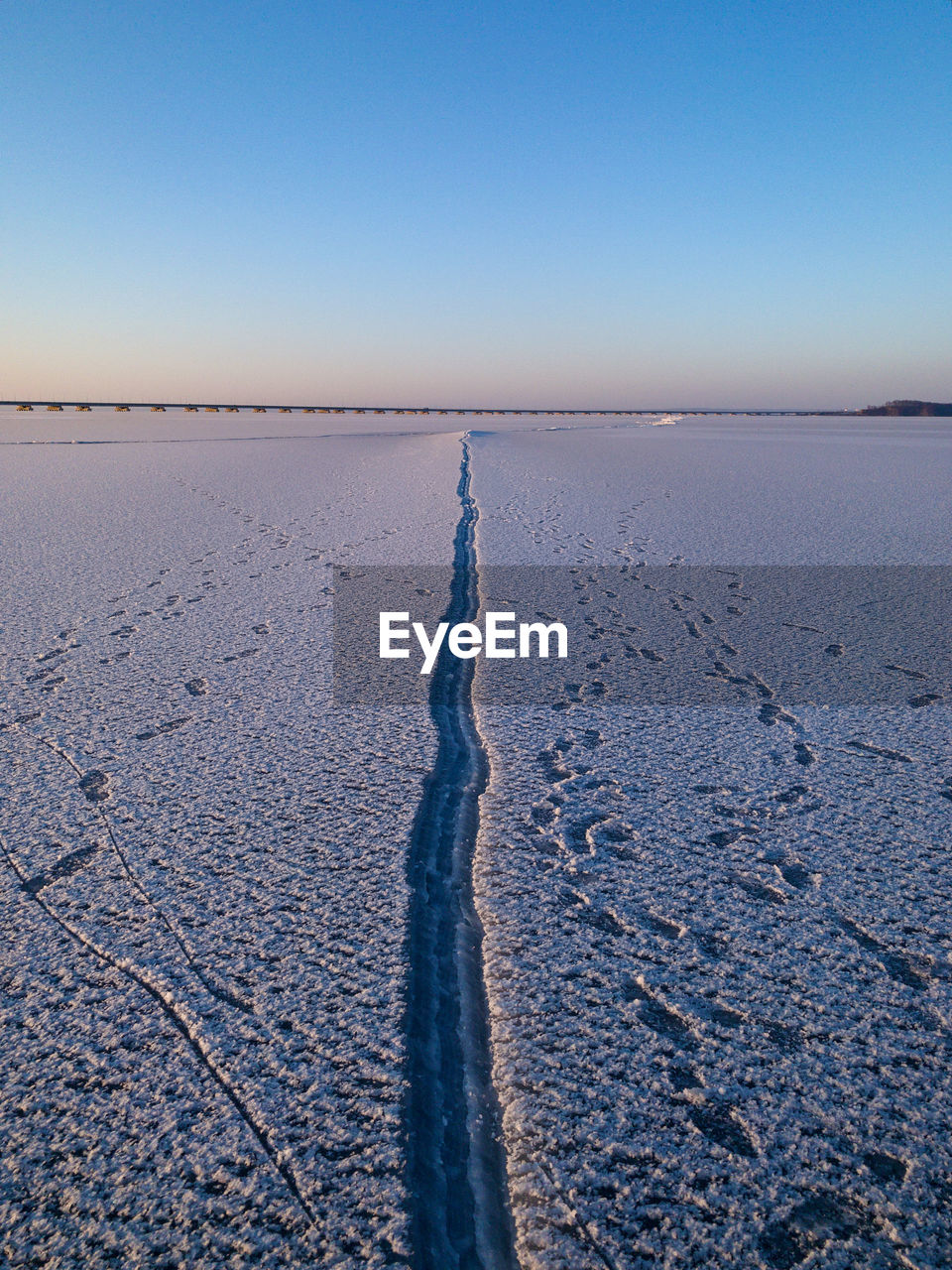 Scenic view of land against clear sky during winter