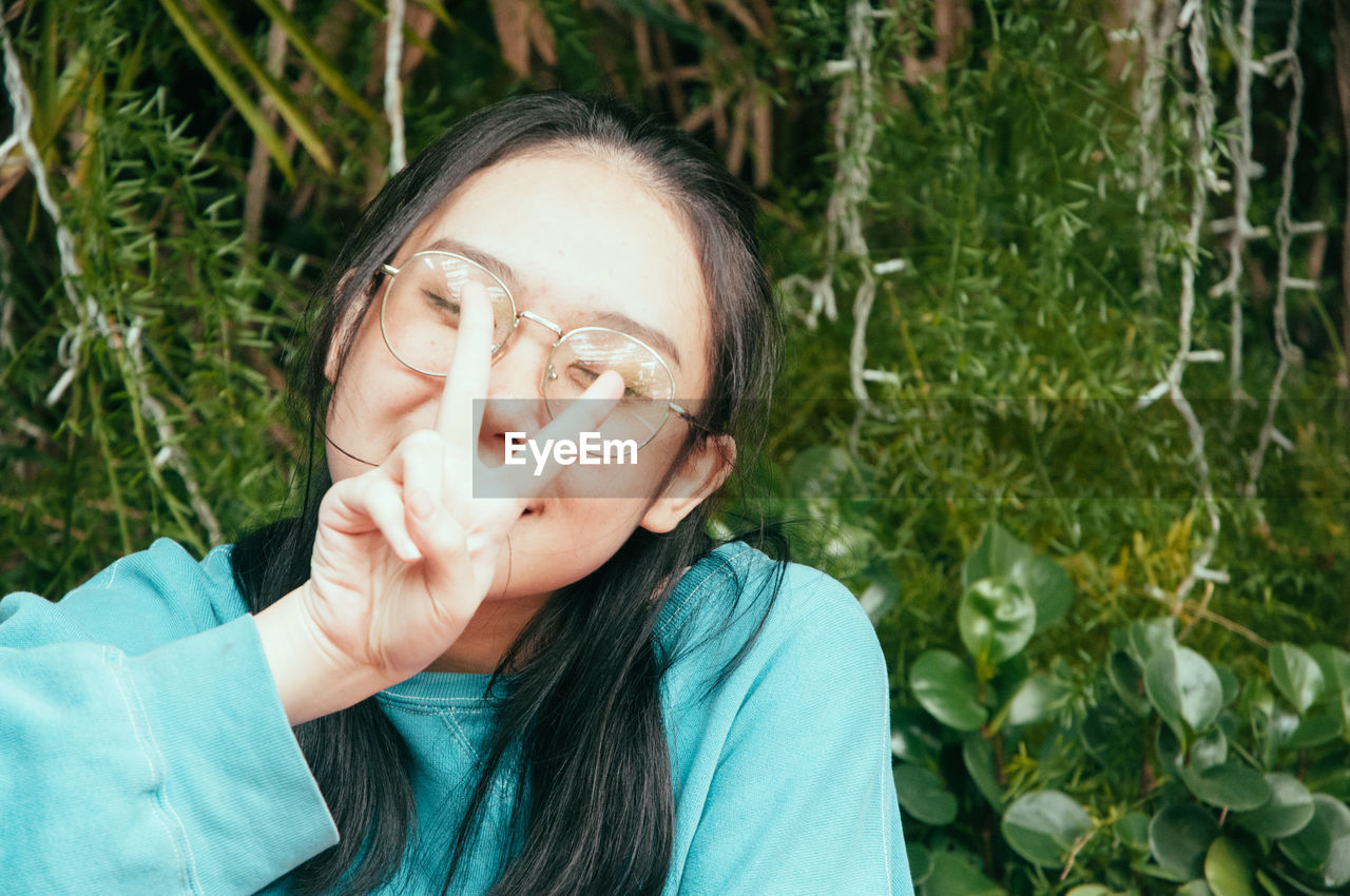 PORTRAIT OF TEENAGE GIRL WEARING EYEGLASSES