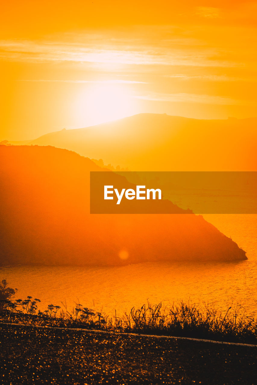 SCENIC VIEW OF SEA AGAINST SKY AT SUNSET